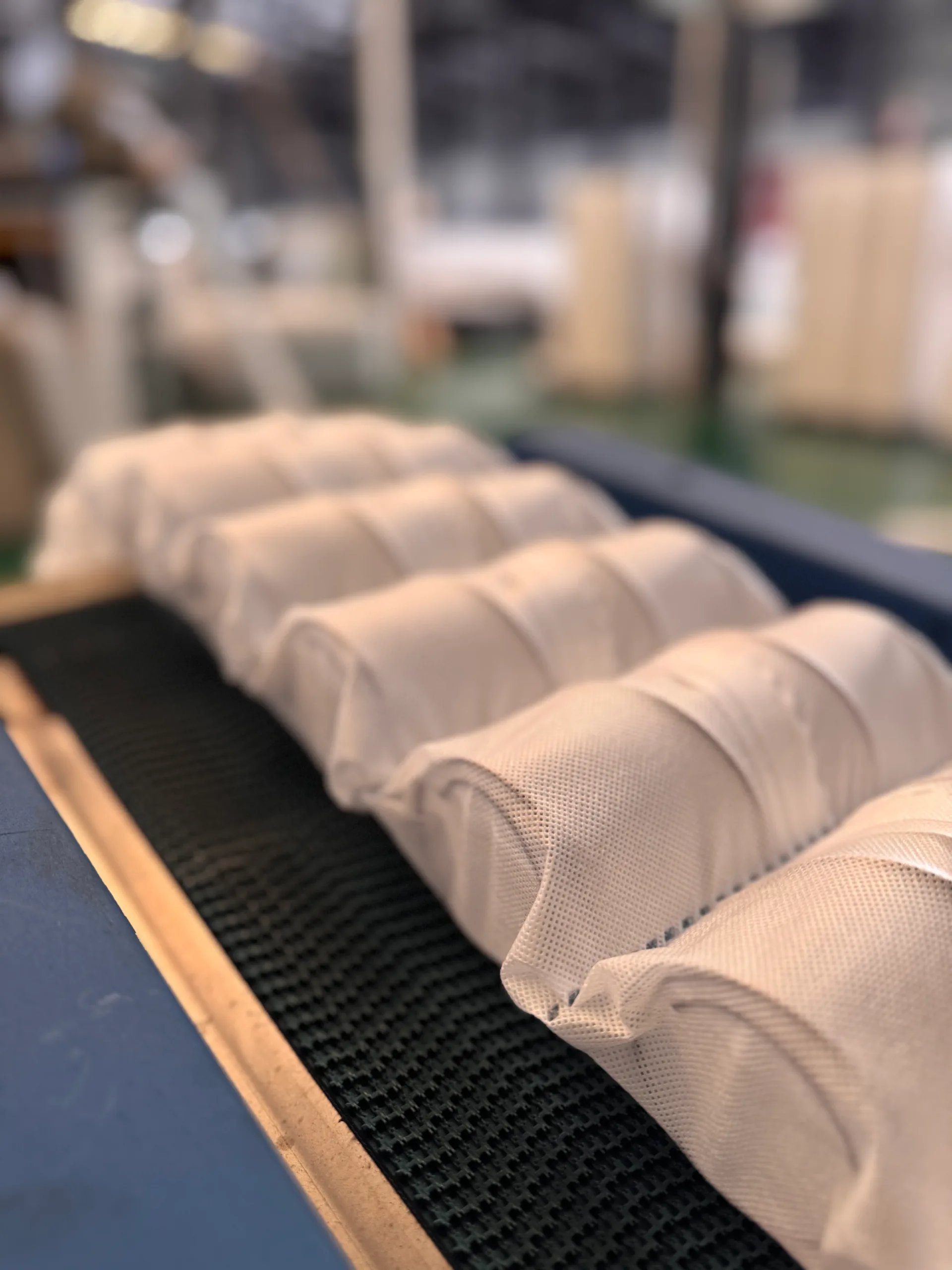Pocket spring units wrapped in PP spunbond nonwoven pouch fabric on conveyor